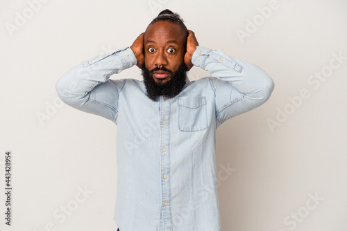 Cuadro en lienzo African american man with beard isolated on pink background covering ears with hands trying not to hear too loud sound