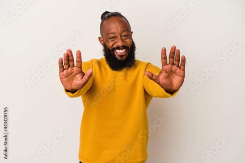 African american man with beard isolated on pink background showing number ten with hands.