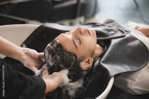 Fototapeta na wymiar hairdresser washing client's hair at salon. happy young women customer relax and comfortable while washing hair, luxury hair spa by professioner hairstylis