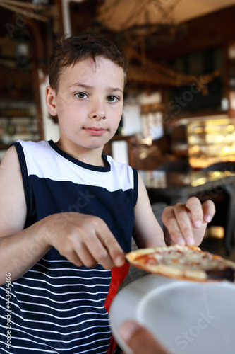 Child eating pizza in restaurant