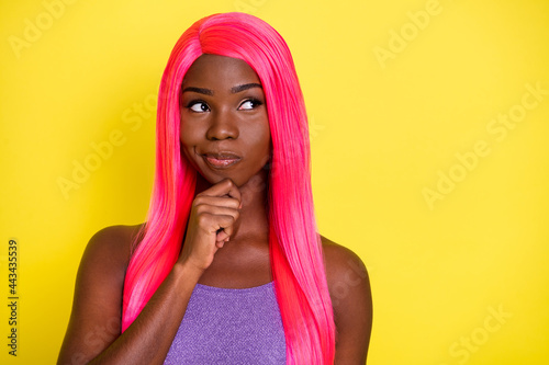 Portrait of serious nice pink hairdo lady hand chin look empty space wear purple top isolated on vivid yellow color background © deagreez