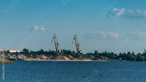 River embankment with cranes for unloading barges © Andrey Nikitin