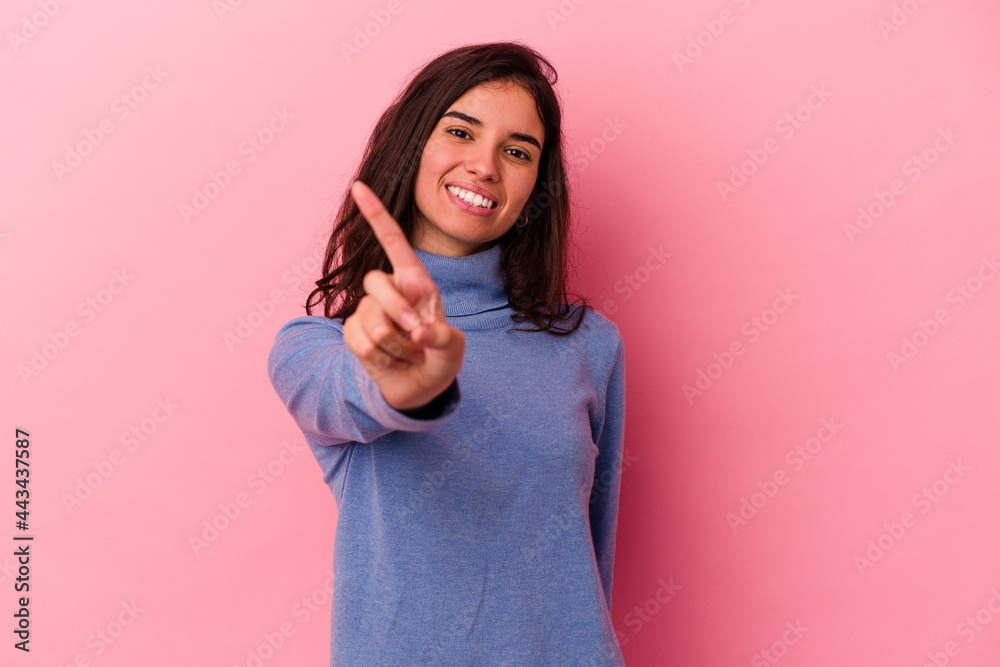 Young caucasian woman isolated on pink background showing number one with finger. Young caucasian woman isolated on pink background showing number one with finger.
