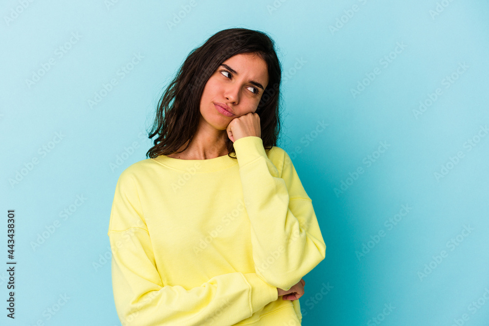 Young caucasian woman isolated on blue background who feels sad and pensive, looking at copy space. Young caucasian woman isolated on blue background who feels sad and pensive, looking at copy space.