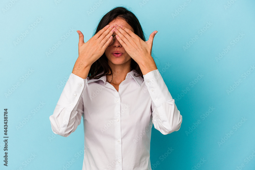 Young caucasian woman isolated on blue background afraid covering eyes with hands. Young caucasian woman isolated on blue background afraid covering eyes with hands.