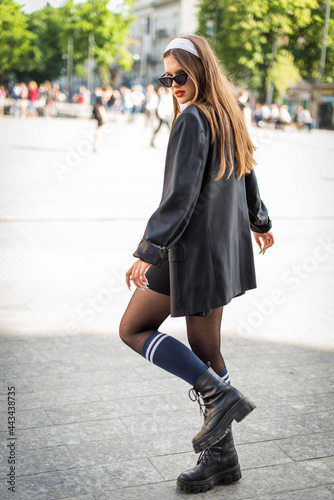 Beautiful country girl in 90s style. Back in time 90s 80s. Stylish girl in retro colourful vintage coat. dressed in street style clothes with chains around neck for a walk. Youth and lifestyle concept