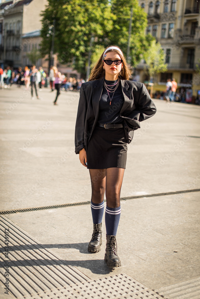 Beautiful country girl in 90s style. Back in time 90s 80s. Stylish girl in retro colourful vintage coat. dressed in street style clothes with chains around neck for a walk. Youth and lifestyle concept