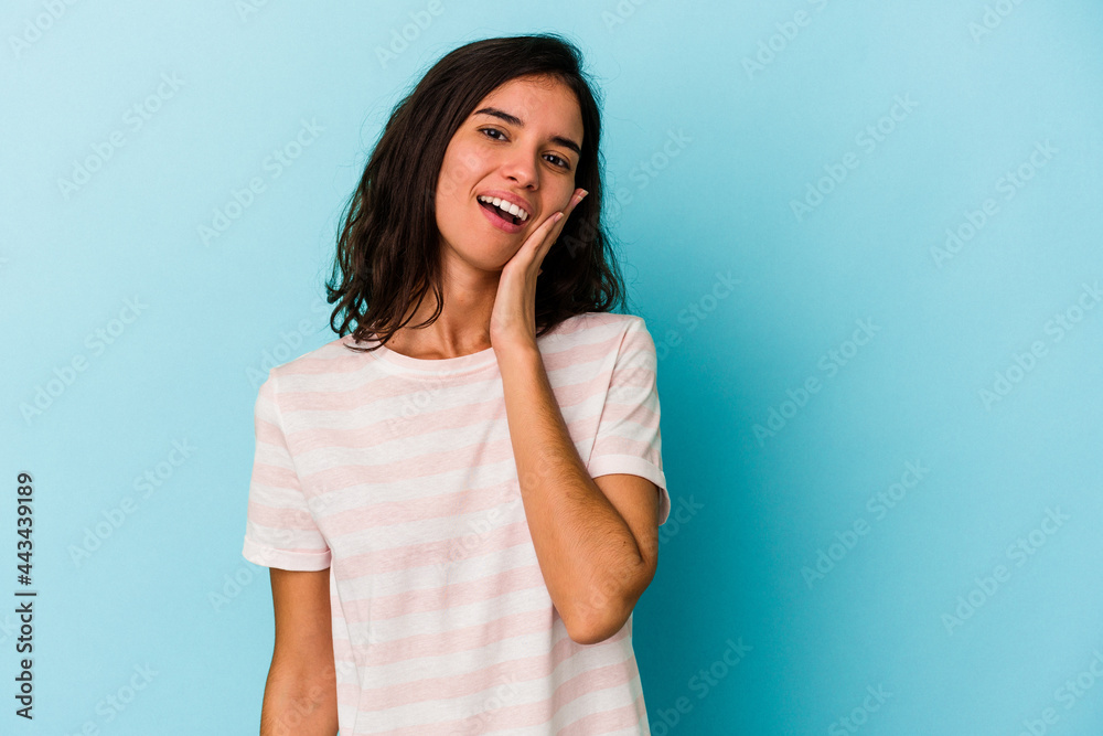 Young caucasian woman isolated on blue background shouts loud, keeps eyes opened and hands tense. Young caucasian woman isolated on blue background shouts loud, keeps eyes opened and hands tense.