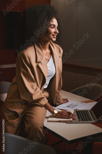 Enthusiastic young businesswoman feeling happy at work