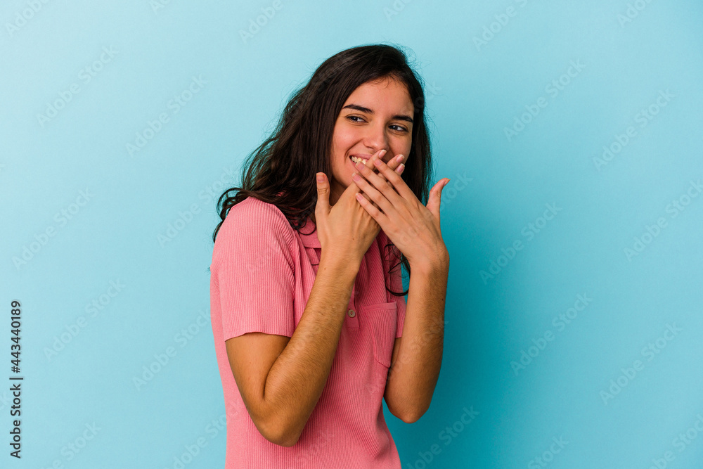 Young caucasian woman isolated on blue background laughing about something, covering mouth with hands. Young caucasian woman isolated on blue background laughing about something, covering mouth with hands.