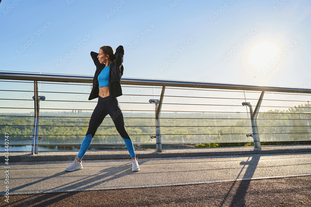 Active young woman doing fitness in fresh air