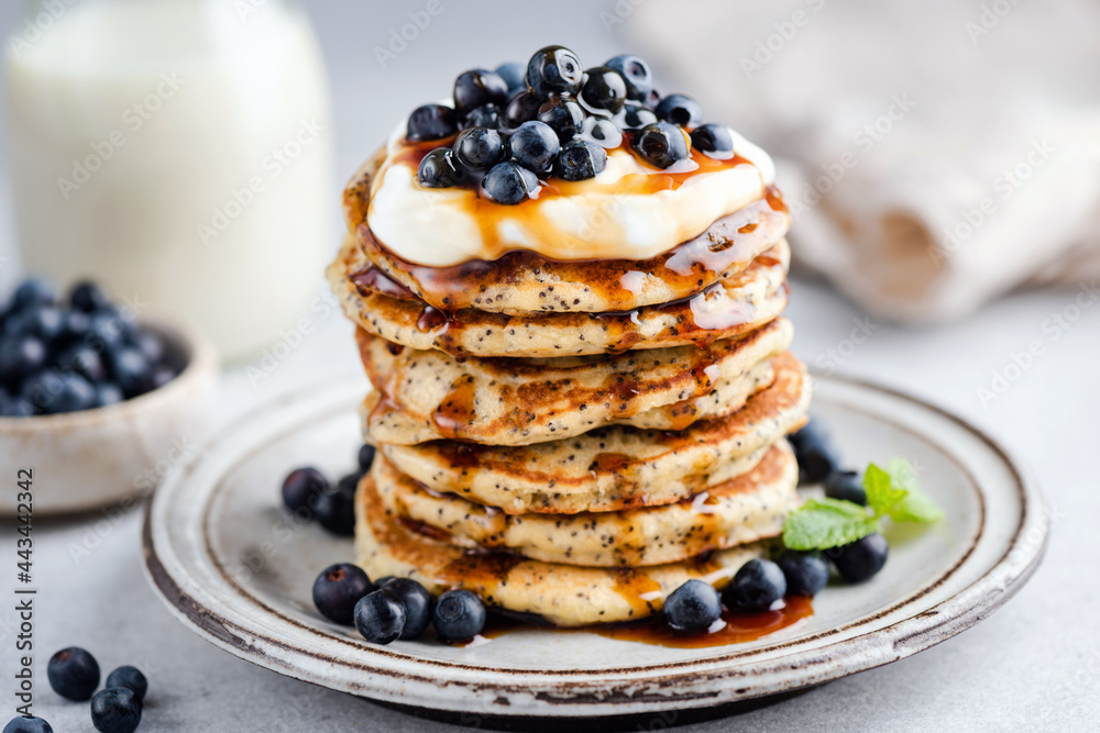 Stack of tasty Poppy seed Pancakes with maple syrup, yogurt and blueberries. Sweet breakfast food Stack of tasty Poppy seed Pancakes with maple syrup, yogurt and blueberries. Sweet breakfast food