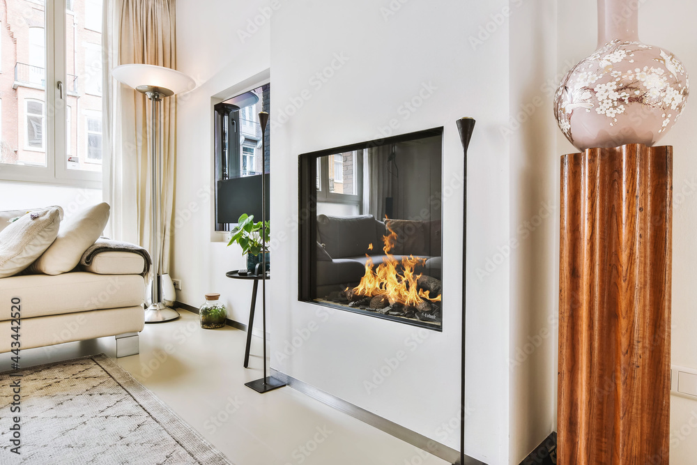 Stylish fireplace in a spacious living room - obrazy, fototapety, plakaty 