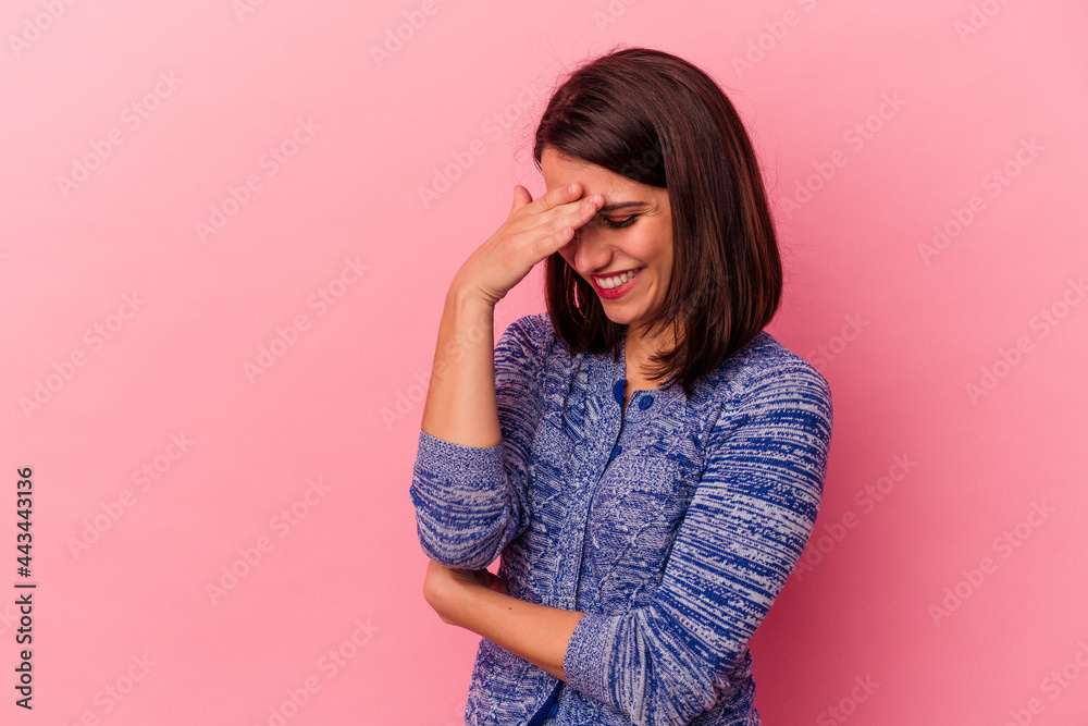 Young caucasian woman isolated on pink background blink at the camera through fingers, embarrassed covering face. Young caucasian woman isolated on pink background blink at the camera through fingers, embarrassed covering face.