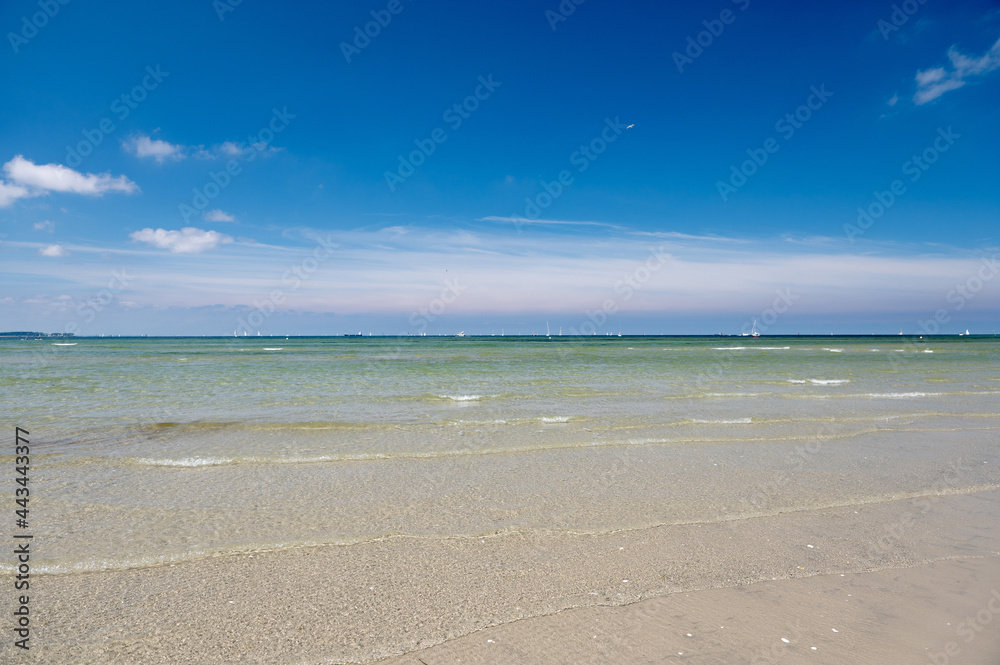 Blue sky with clear water and sailboards  away from the coast