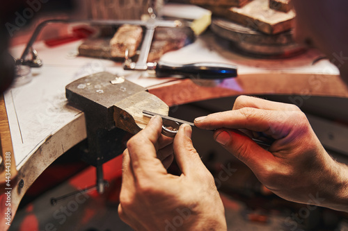 Jeweler is polishing workpiece with hand file