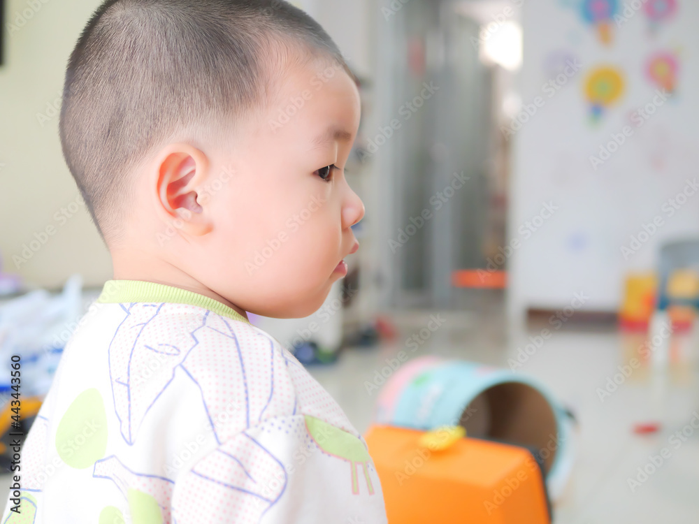 Chinese little boy sitting on the floor and playing with toys in the living room Chinese little boy sitting on the floor and playing with toys in the living room