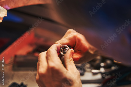 Fototapeta Jewelry master using mandrel for polishing ring