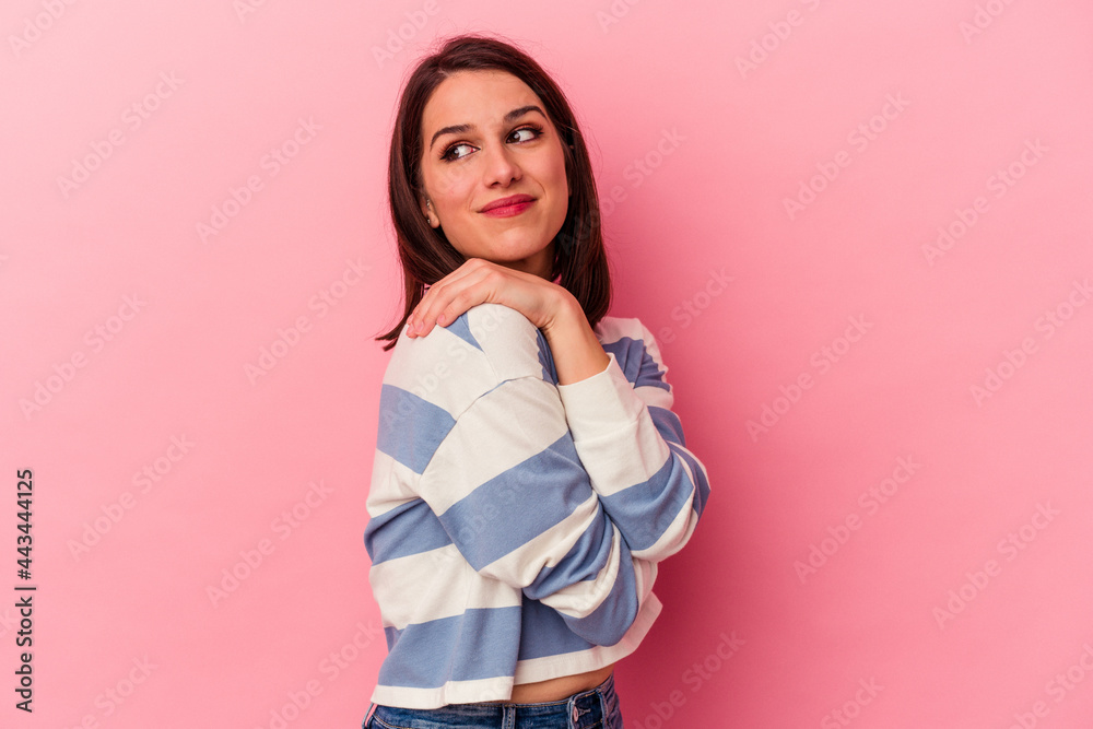 Young caucasian woman isolated on pink background hugs, smiling carefree and happy. Young caucasian woman isolated on pink background hugs, smiling carefree and happy.