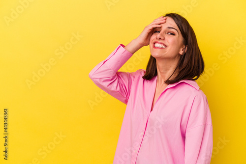 Young caucasian woman isolated on yellow background laughing happy, carefree, natural emotion.