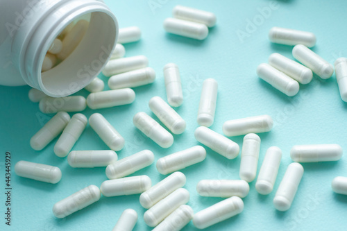 A lot of pills and capsules, medication on blue background. Healthy concept.