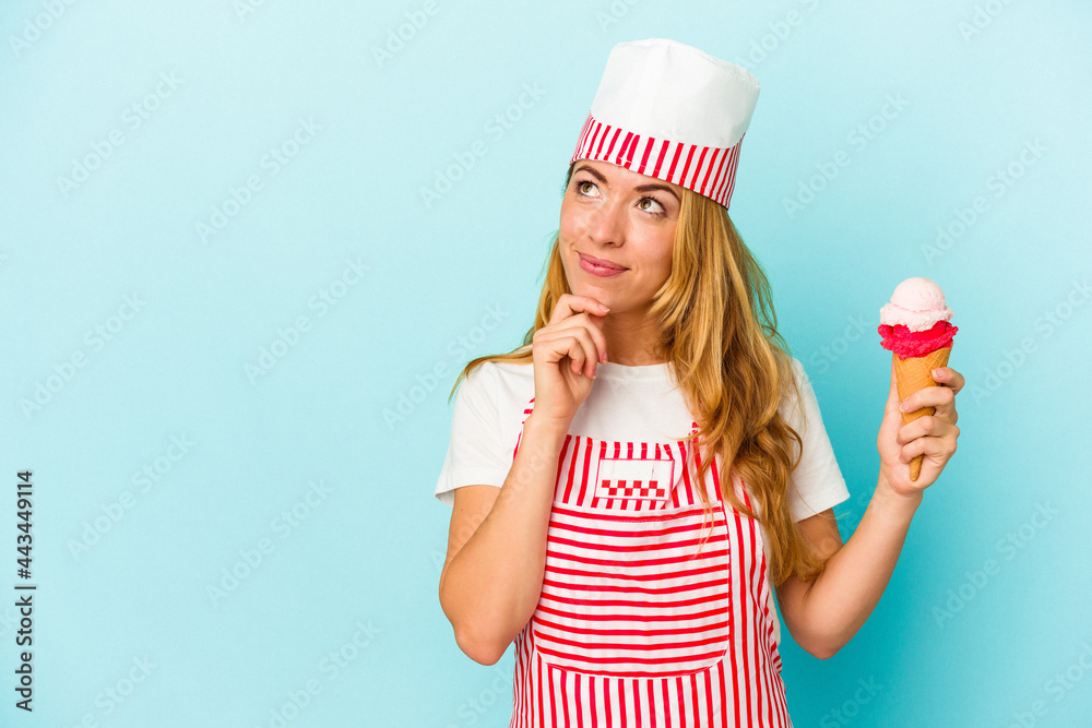 Caucasian ice cream maker woman holding an ice cream isolated on blue background looking sideways with doubtful and skeptical expression. Caucasian ice cream maker woman holding an ice cream isolated on blue background looking sideways with doubtful and skeptical expression.