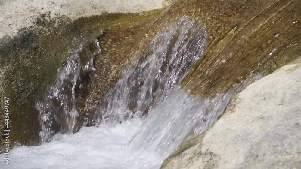 Close-up view of water flows down large stones. Mountain river. Nature and reserves. 4K UHD