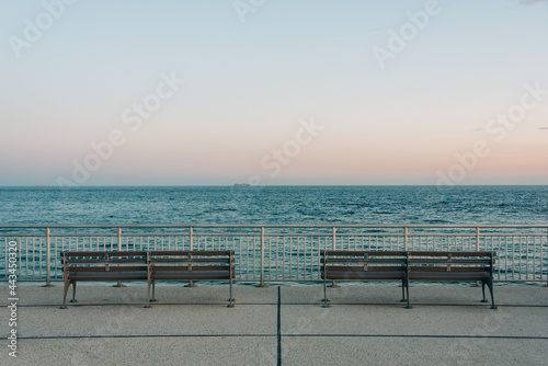 Benches on the Rockaways Boardwalk and view of the beach  in Queens  New York City
