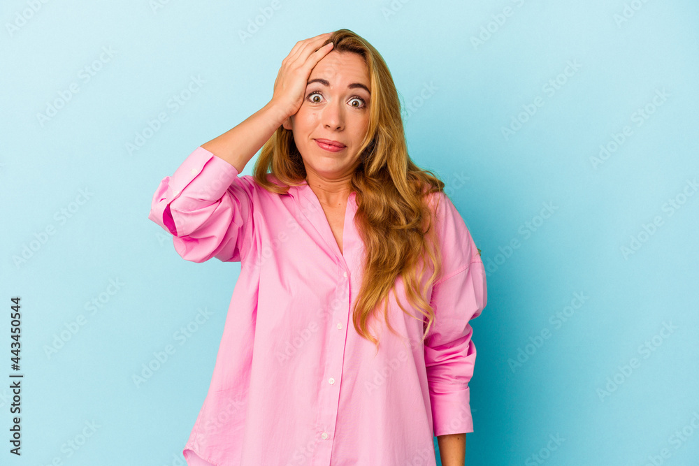Caucasian woman isolated on blue background being shocked, she has remembered important meeting.