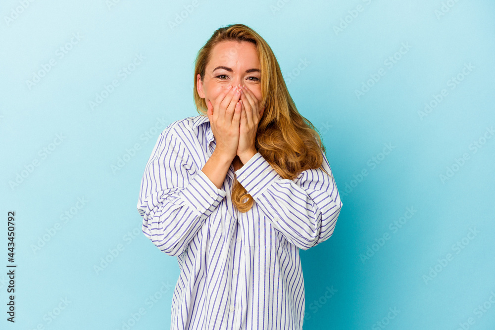 Caucasian woman isolated on blue background laughing about something, covering mouth with hands. Caucasian woman isolated on blue background laughing about something, covering mouth with hands.