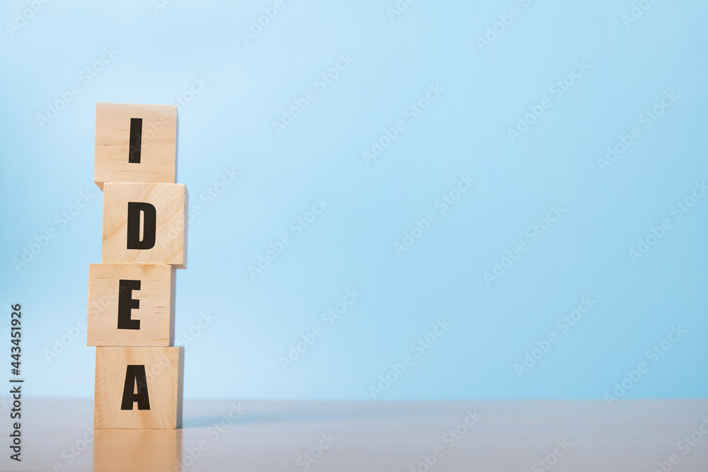 arranging wood cube stacking with idea text on blue background. arranging wood cube stacking with idea text on blue background.