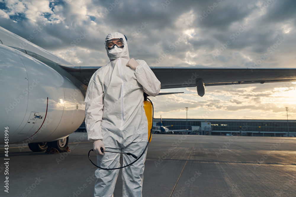 Man in a hazmat suit standing at the airdrome