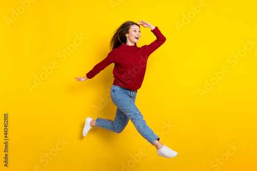 Fototapeta Naklejka Na Ścianę i Meble -  Full length body size view of attractive amazed cheerful girl jumping walking searching news isolated over bright yellow color background