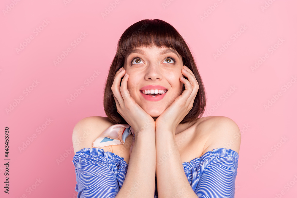 Photo of lovely happy nice young woman look empty space hold hands face isolated on pink color background Photo of lovely happy nice young woman look empty space hold hands face isolated on pink color background