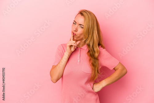 Caucasian blonde woman isolated on pink background keeping a secret or asking for silence.