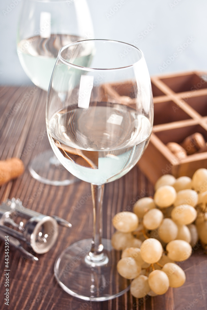 Glasses of white grape wine with grapes and wooden box on the background Glasses of white grape wine with grapes and wooden box on the background