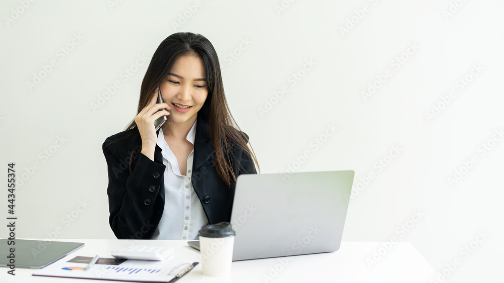 A woman works on a computer and mobile phone with a calculator calculating household finances or taxes on board. A woman managing family expenses at home or a female accountant. Bank consultants and a A woman works on a computer and mobile phone with a calculator calculating household finances or taxes on board. A woman managing family expenses at home or a female accountant. Bank consultants and a