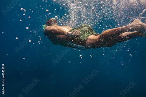 Man swimming underwater into the ocean © archimede