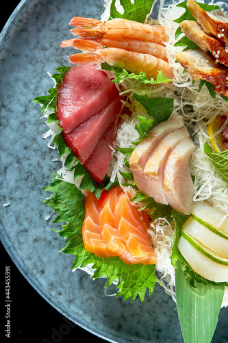 Assorted sashimi of salmon, shrimp, tuna, octopus, scallop and eel. Classic Japanese cuisine. Food delivery. Isolated on black