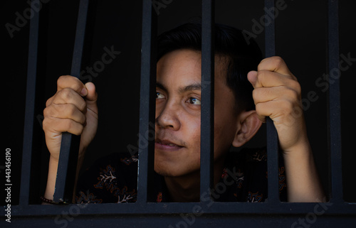 expression of man holding bars in prison
