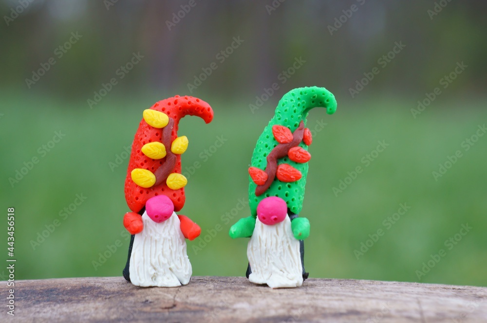 Two colorful dwarfs made of plasticine in the forest.