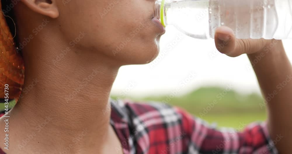 young farmer drinks from a bottle to relieve thirst. young farmer drinks from a bottle to relieve thirst.
