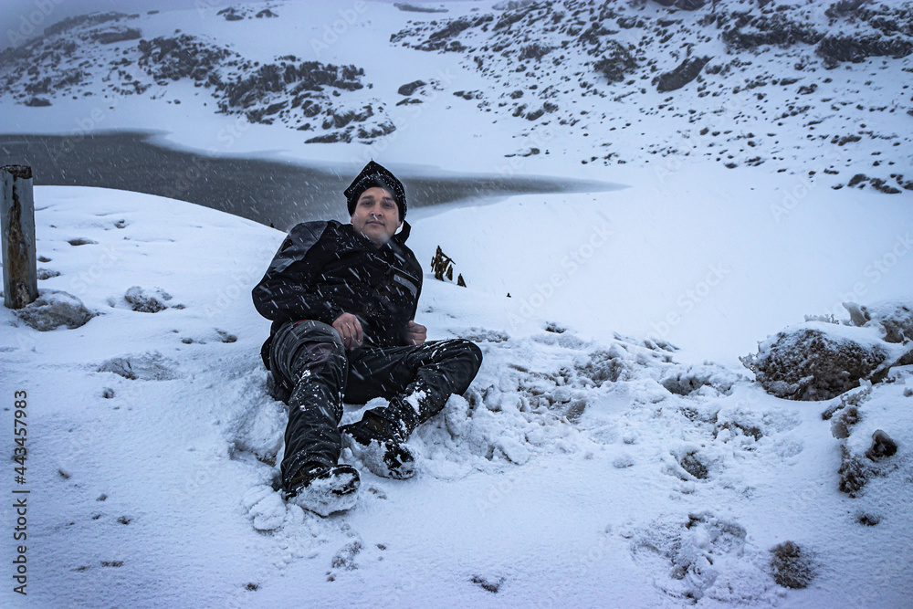 young man enjoying snow fall at himalayan mountains at morning young man enjoying snow fall at himalayan mountains at morning
