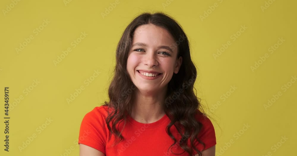 Beautiful woman giving thumbs up gesture over yellow background Beautiful woman giving thumbs up gesture over yellow background