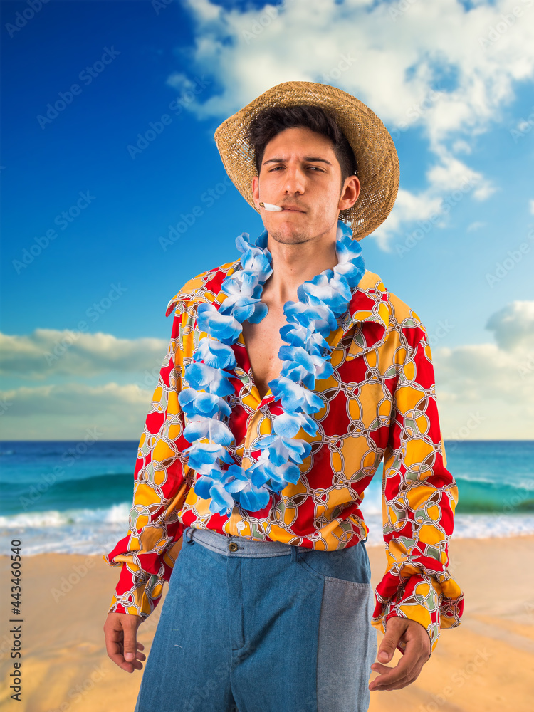 Young man smoking cigarette on beach, with hippie clothing