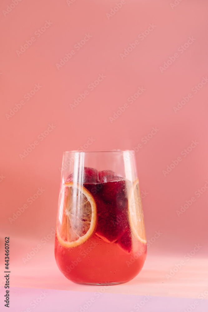 red cocktail with soda in a large glass glass on a pink background red cocktail with soda in a large glass glass on a pink background