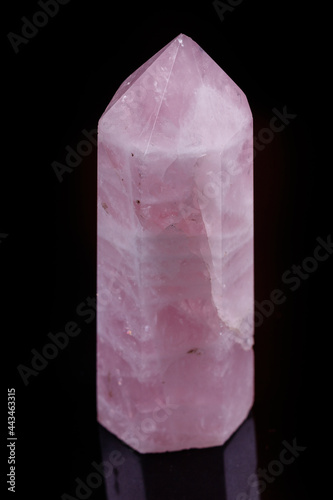 Macro mineral pink quartz crystal on a black background