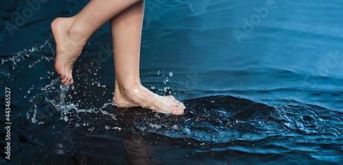 Woman foot step on blue Water in Splash photo