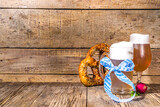 Oktoberfest various beer glasses and mugs with pretzel, wheat and hops. Bar and pub menu, invitation card background on wooden background copy space