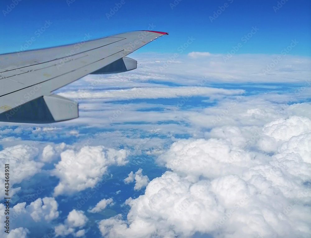 Obraz premium Viewed from airplane windows with a wing, blue sky and white cloud